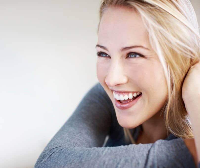 Closeup of attractive young woman smiling while looking at away - copyspace