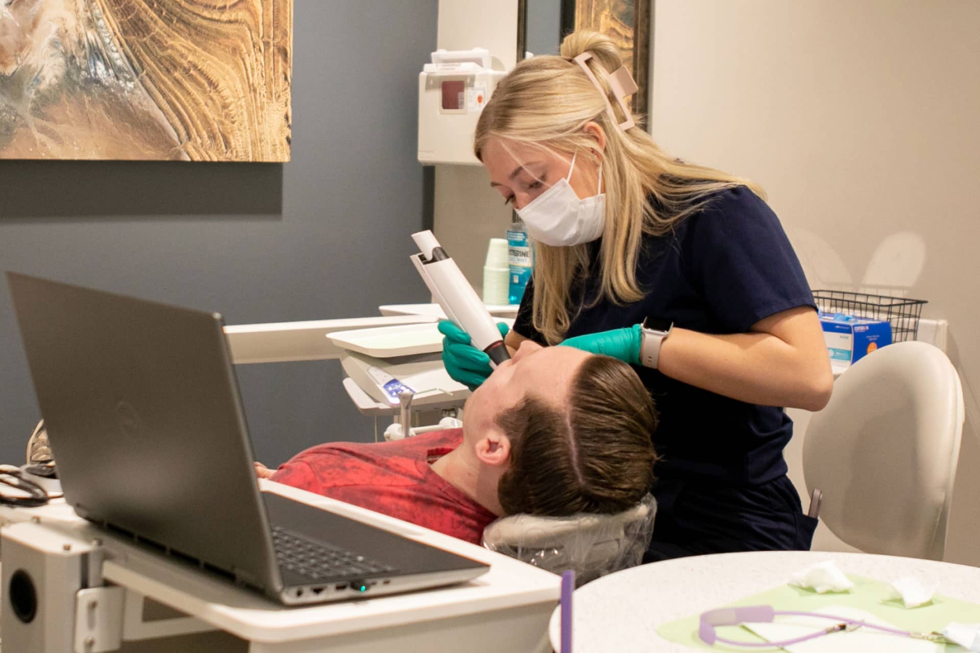 dental assistant using intraoral camera on patient in exam room