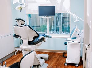 Dental exam room with blue and white dental chair, solea equipment, and window showing the outside