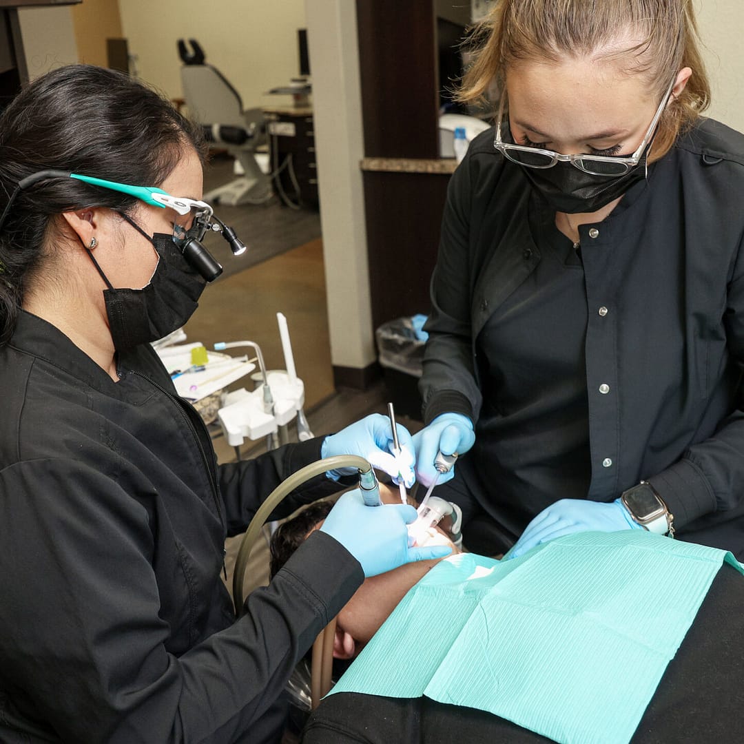 dentist and assistant performing dental procedure on patient