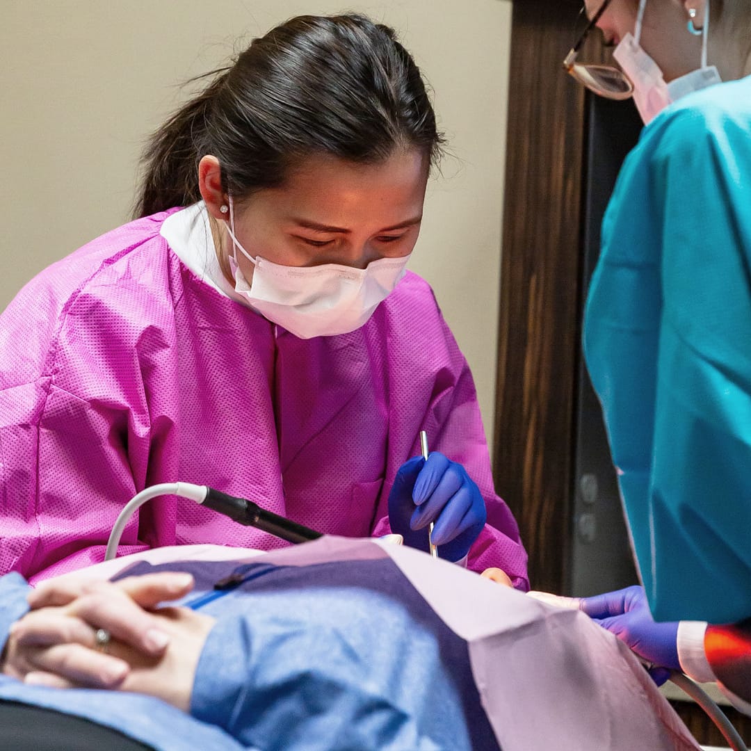 dentist and assistant performing dental procedure on patient