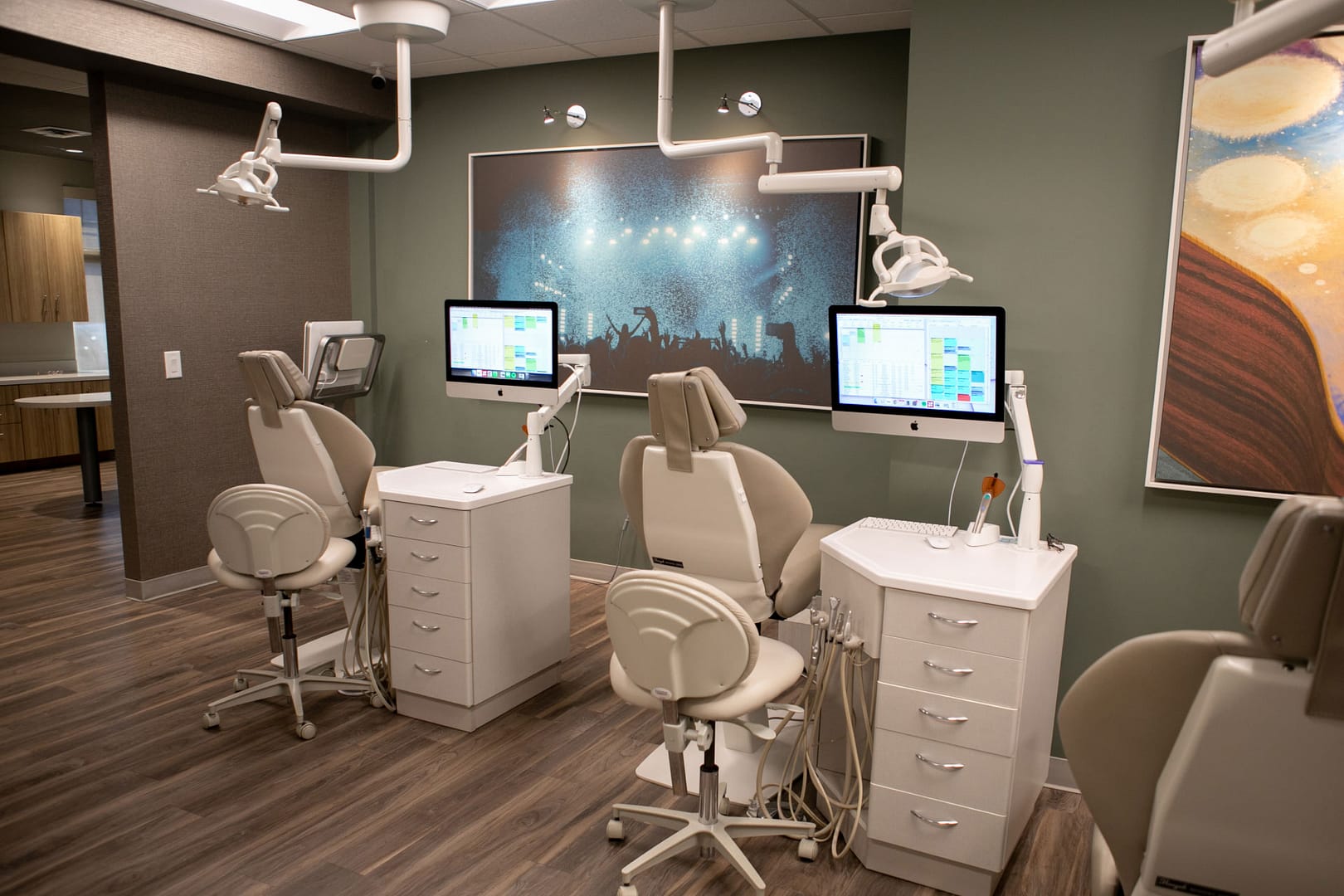 exam room with dental chairs and equipment and large artwork on walls