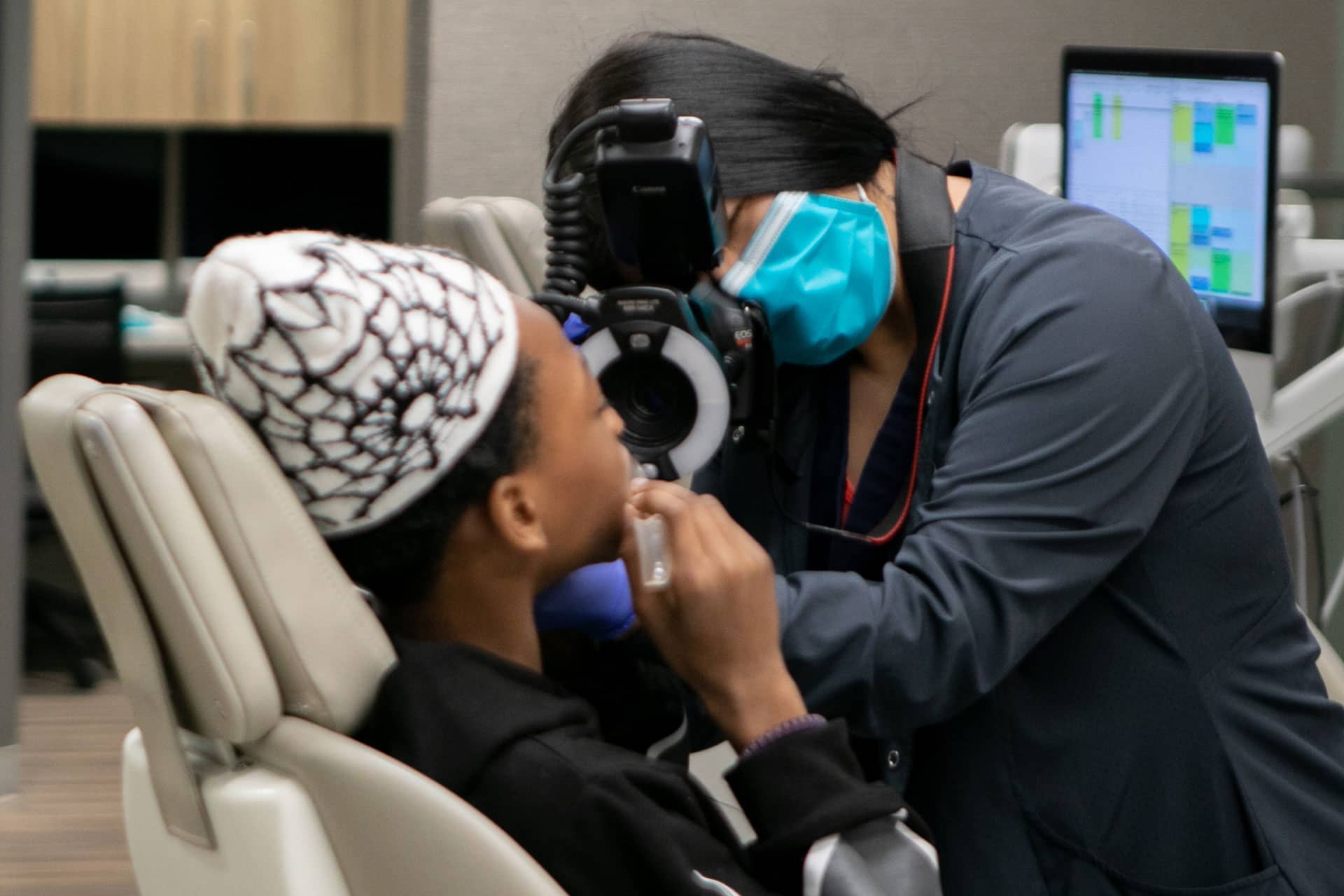 assistant taking photos of patient's teeth