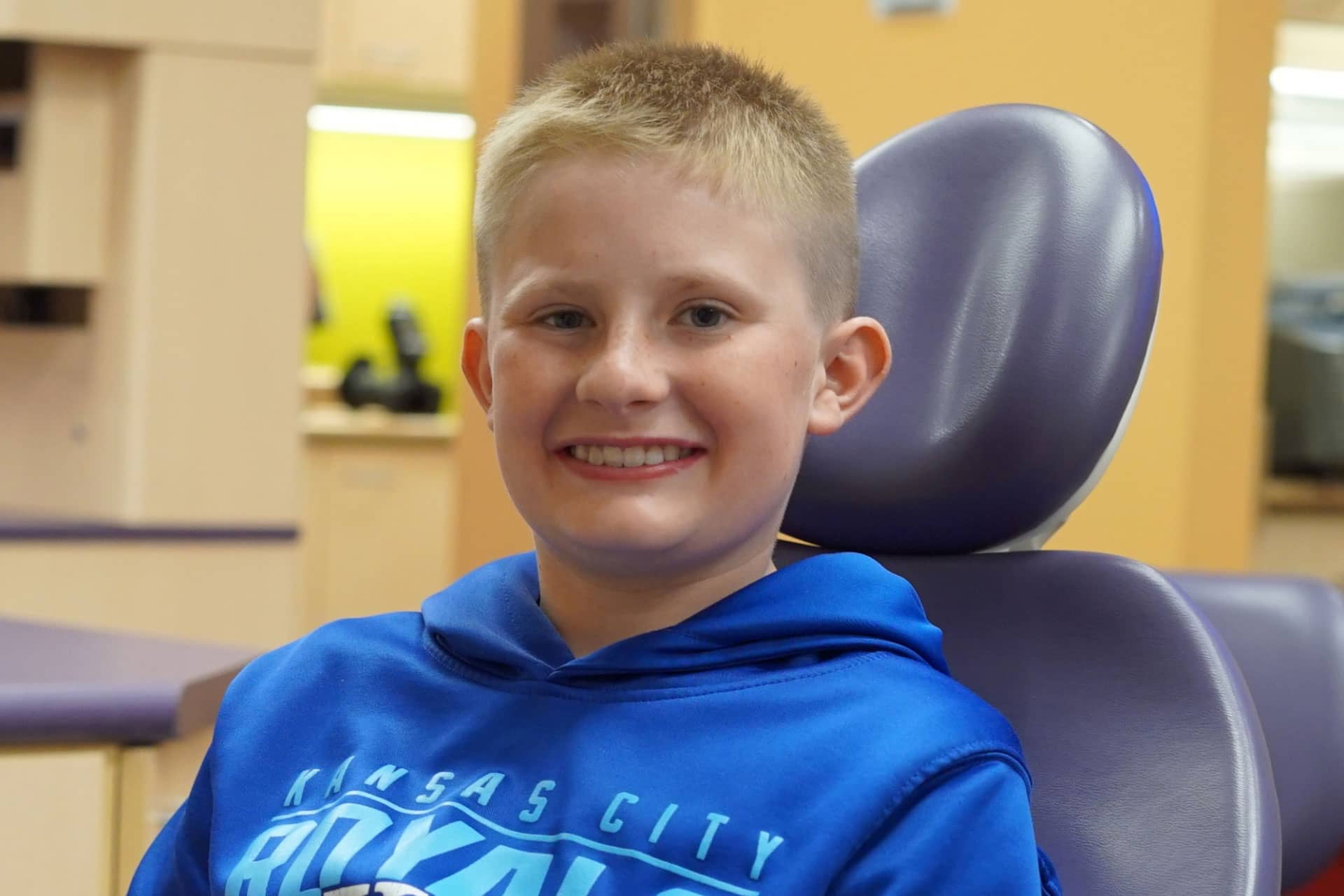 teen boy sitting in dental chair and smiling