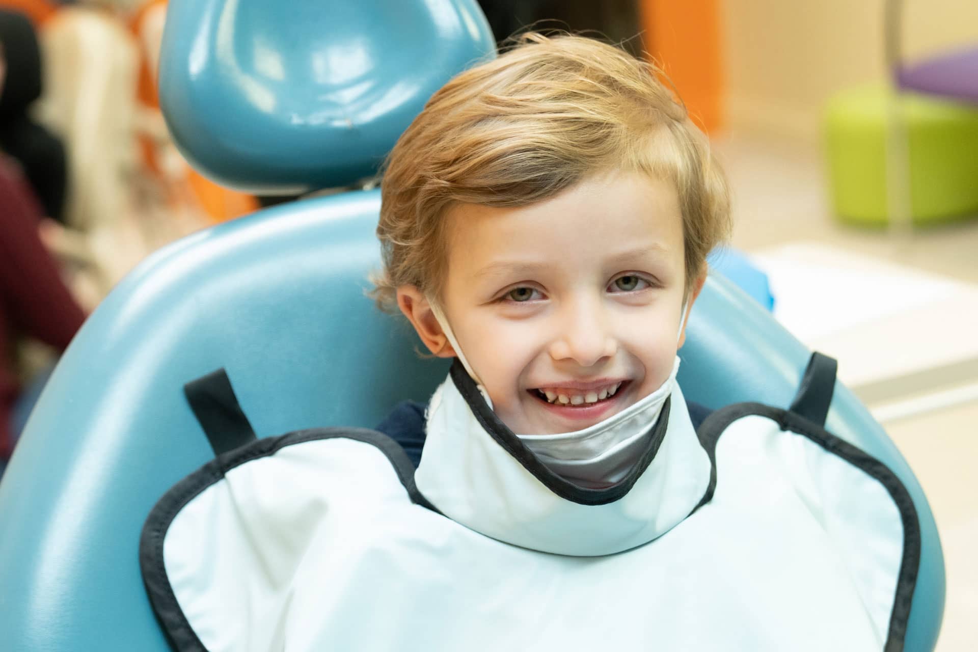 pediatric patient wearing xray cape in dental chair