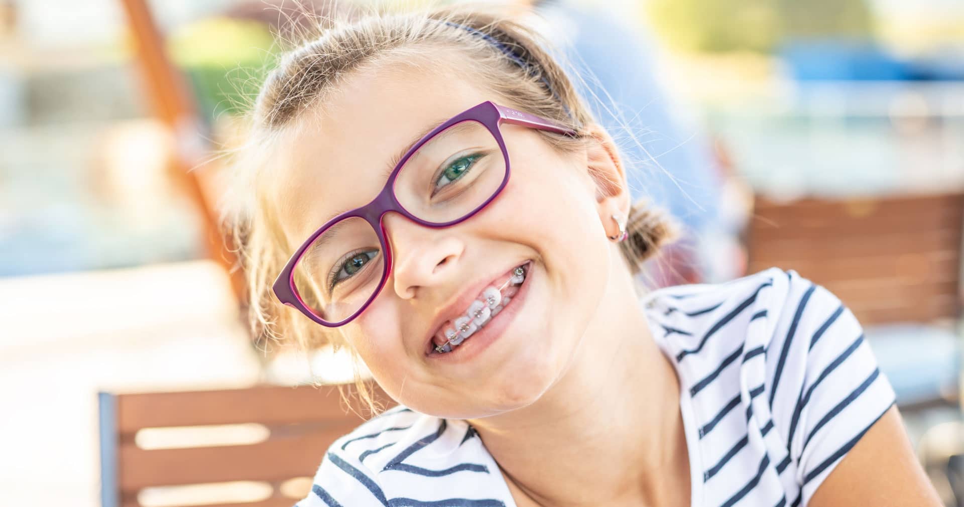 preteen girl with braces and purple glasses