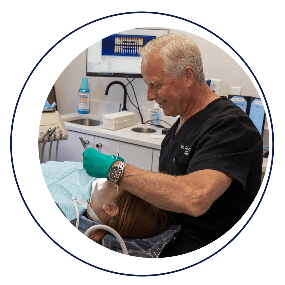 Dr. Tim performing dental procedure on patient