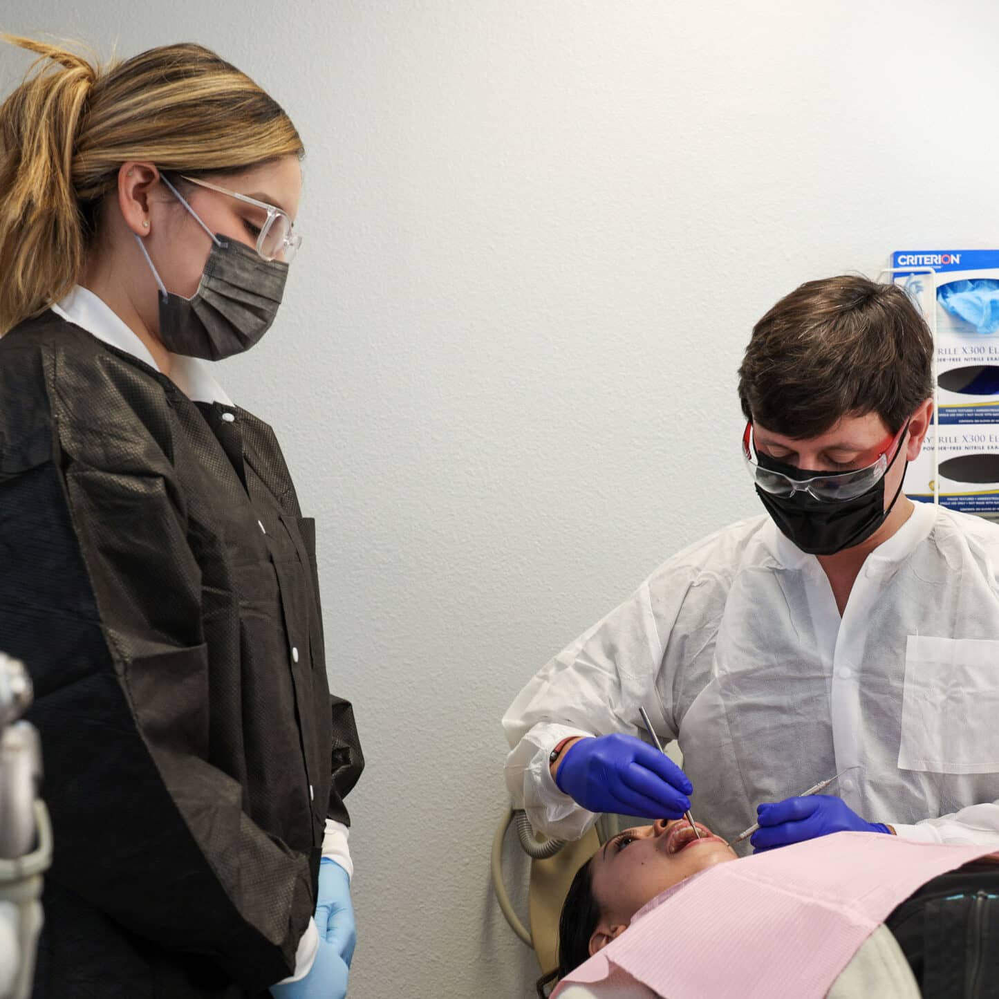 dentist and team member with patient in exam room