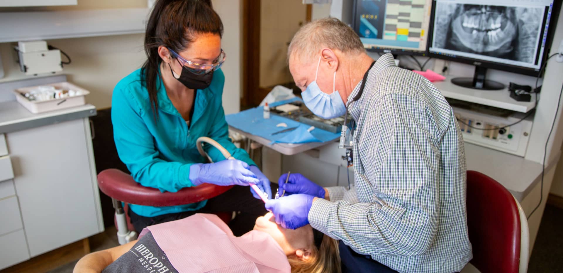 Dr. Spencer and team member performing dental procedure on patient