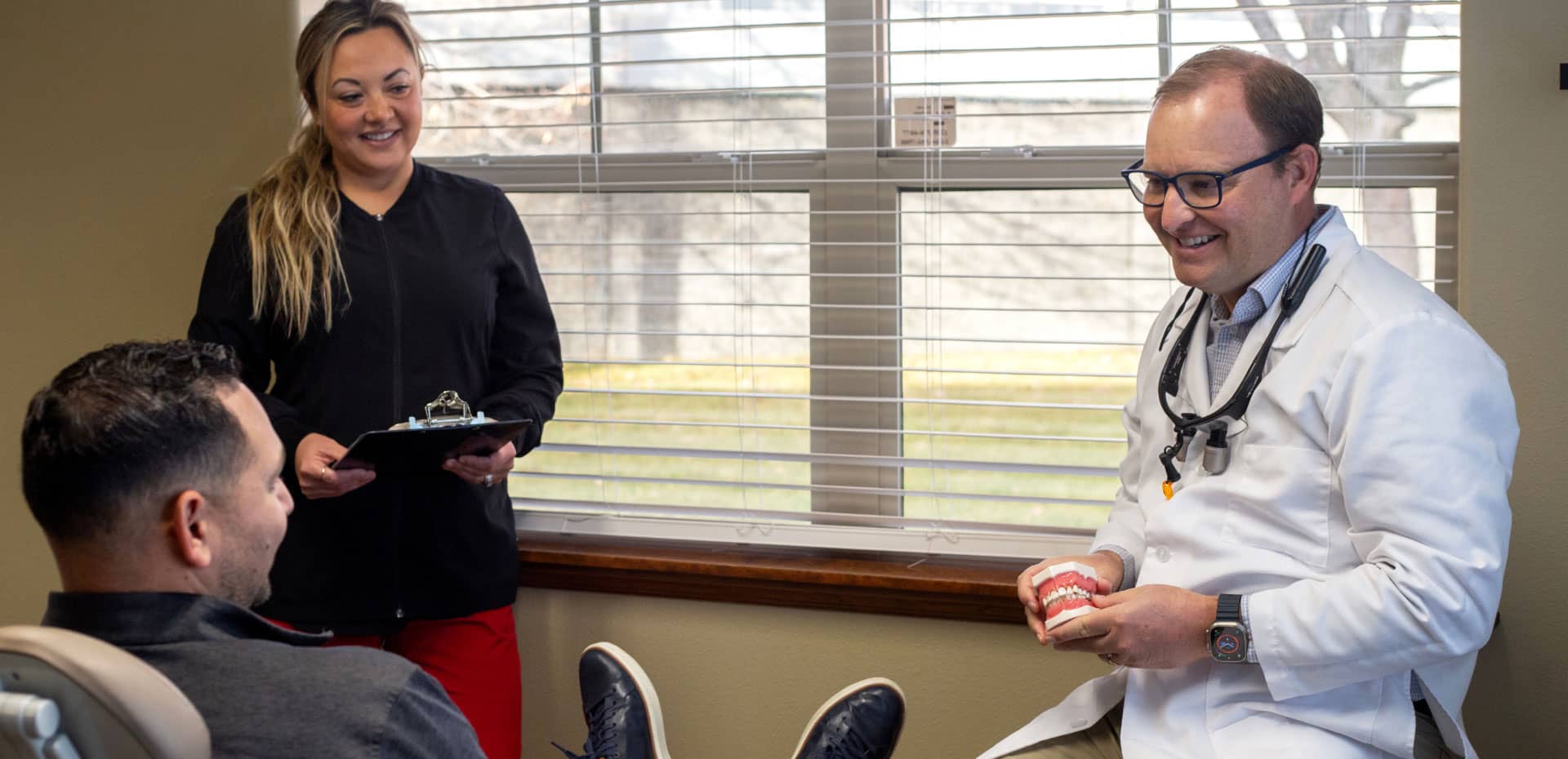 dr. staley and assistant talking to patient in exam room