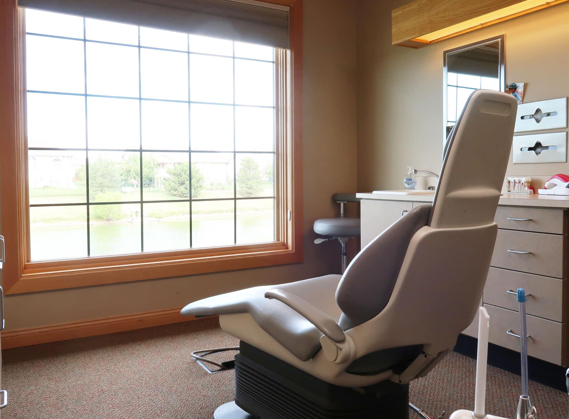 dental exam room with dental chair facing large window looking outside