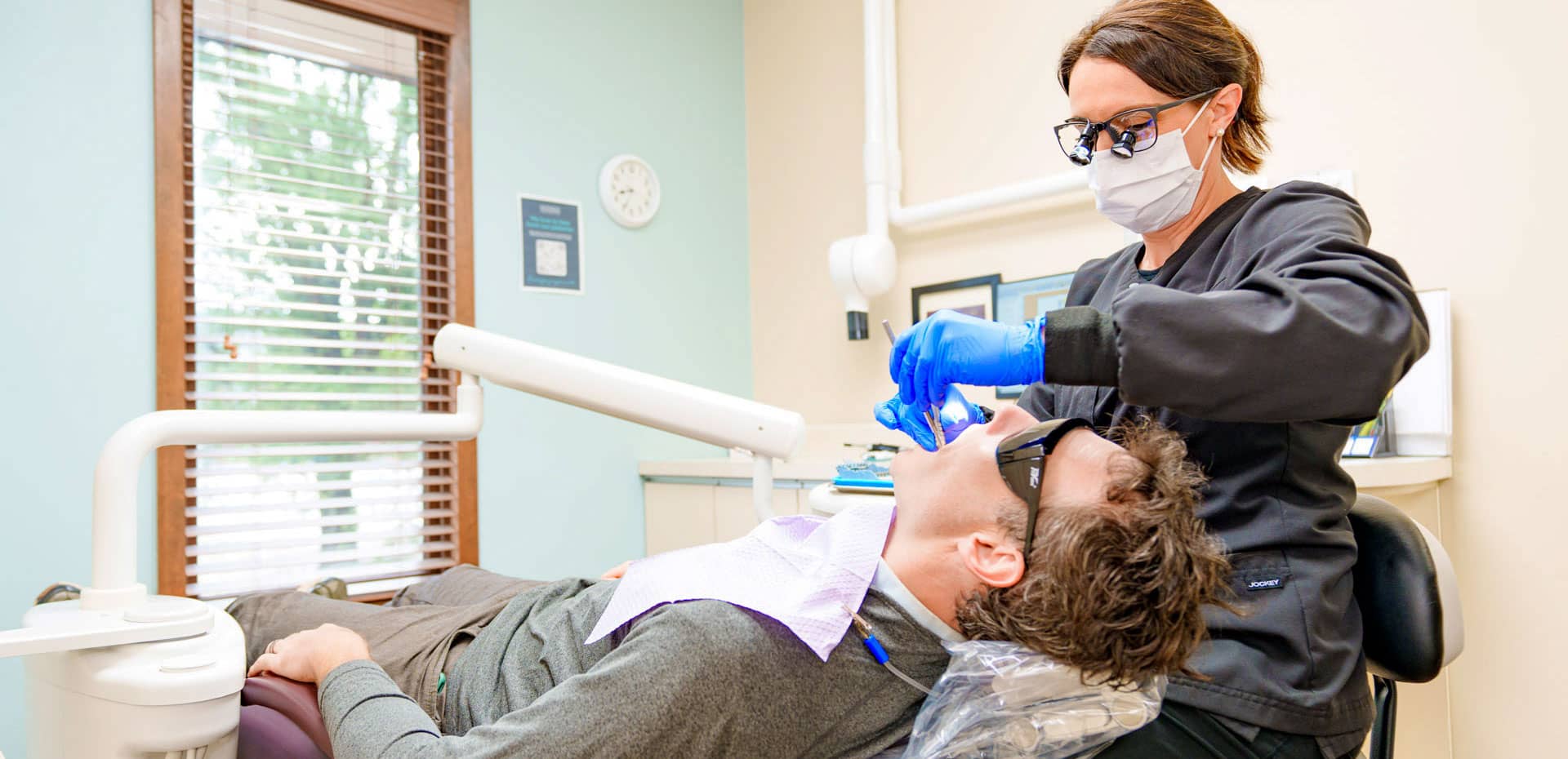 assistant performing dental procedure on patient
