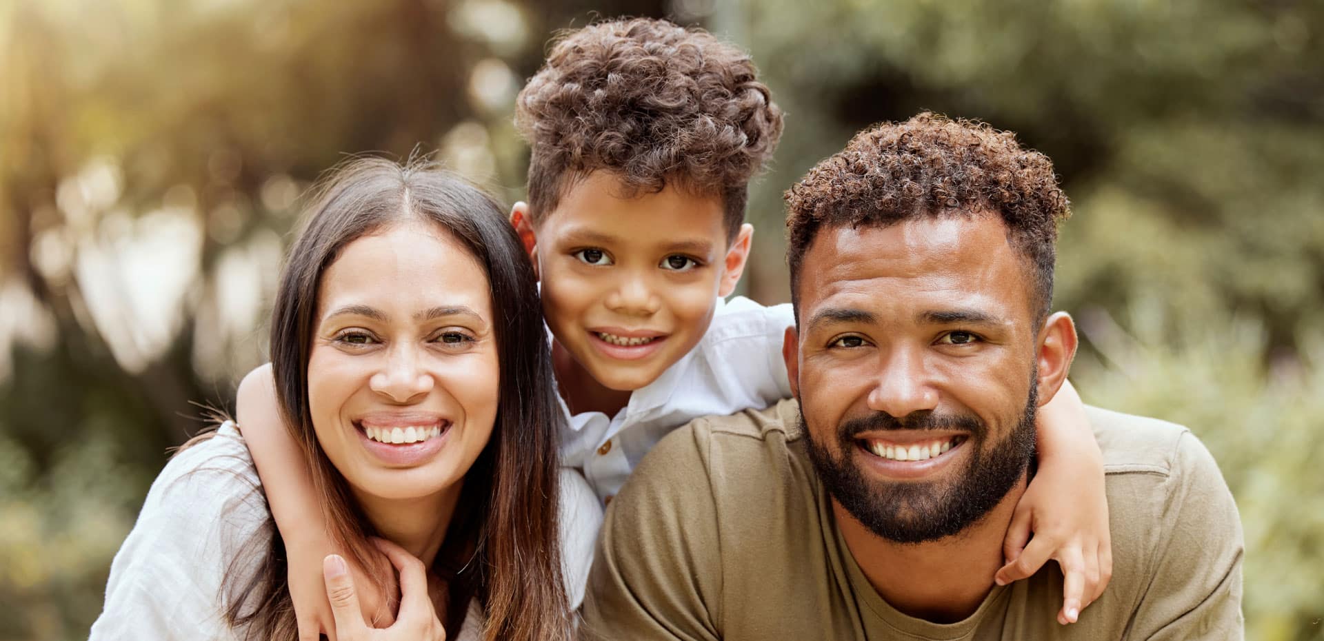 african american family of 3 smiling outside