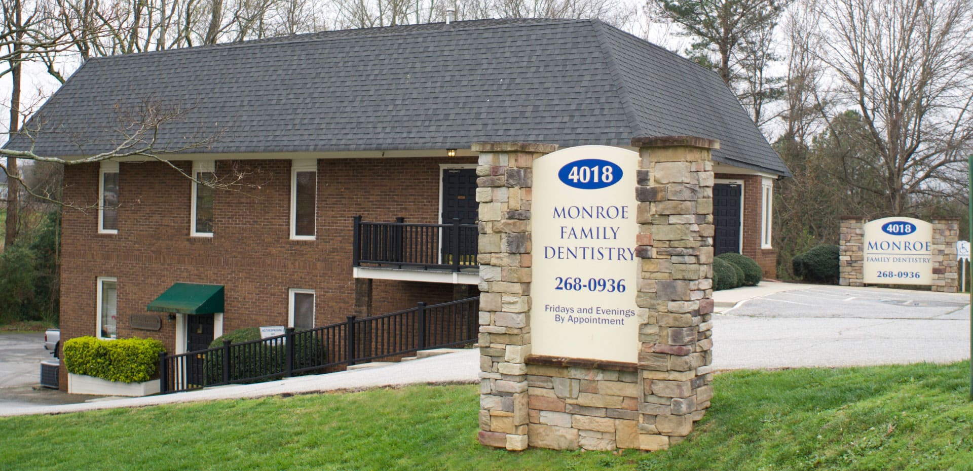 Monroe Family Dentistry brick building exterior with 2 signs out front