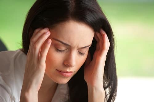 Attractive woman in pain holding her head