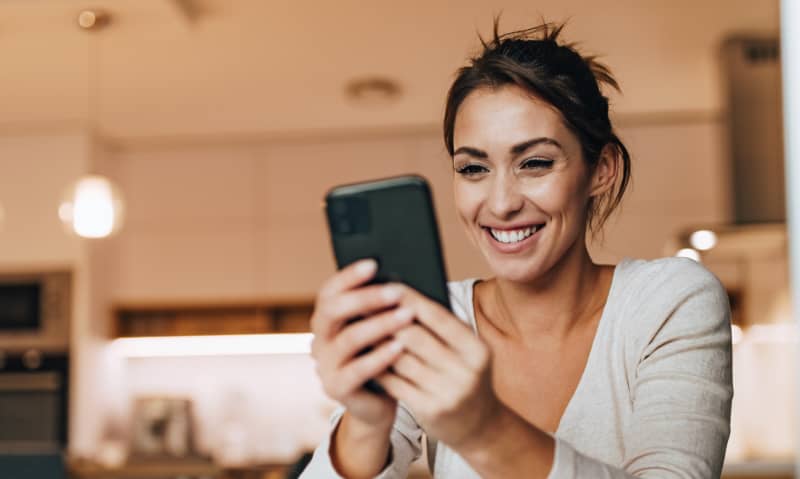 woman smiling at her cell phone
