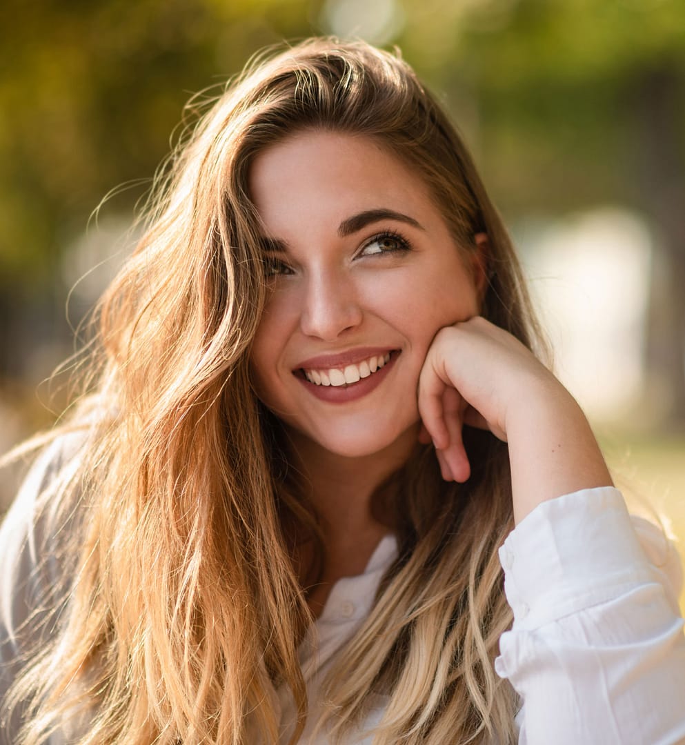 Thoughtful young woman resting chin on hand