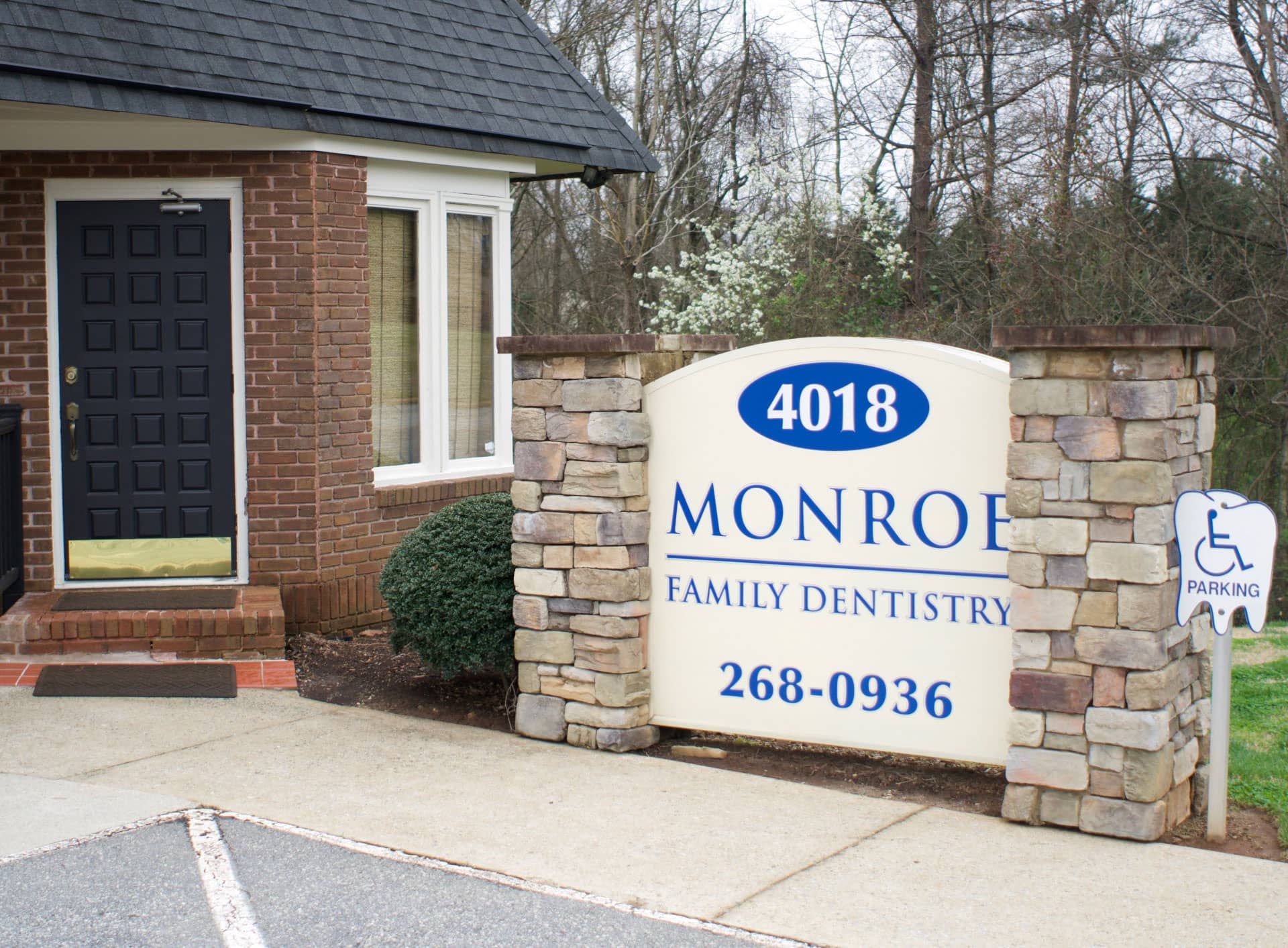 Monroe Family Dentistry office front door with sign and handicap parking out front